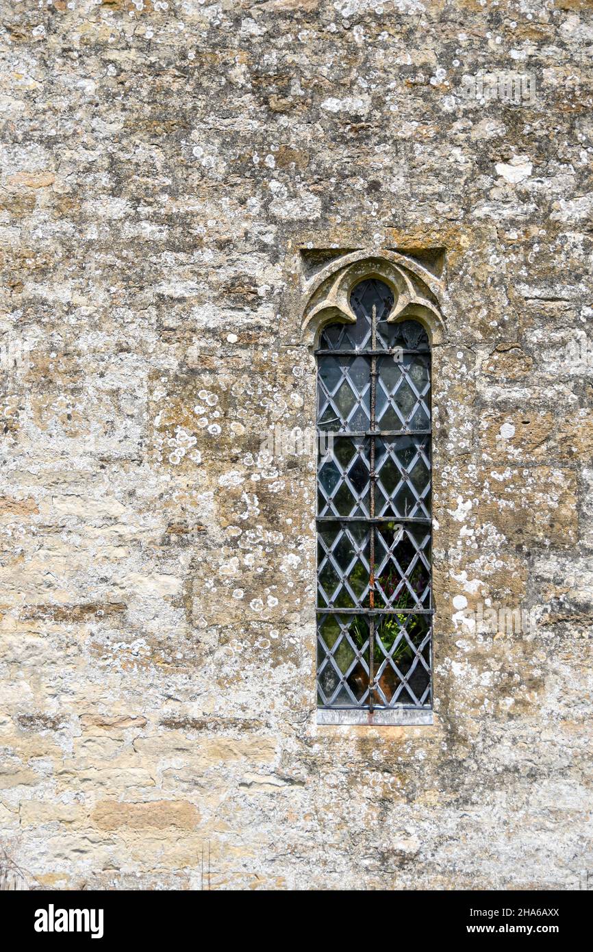 Particolare della parte superiore in acciaio, la finestra a lancetta nella parete esterna della Chiesa di St Oswald, Swinbrook e Widford, Oxfordshire, Inghilterra Foto Stock