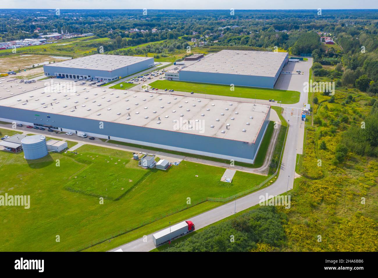 Vista aerea del magazzino con i camion che guidano verso il centro logistico. Contesto industriale. Logistica dall'alto. Foto Stock