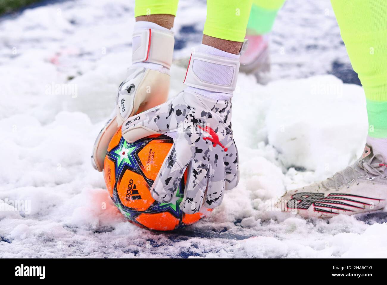 KIEV, UCRAINA - 23 NOVEMBRE 2021: Primo piano mani del portiere Georgiy Bushchan di Dynamo Kyiv con palla arancione su una neve vista durante la partita della UEFA Champions League contro Bayern Munchen Foto Stock
