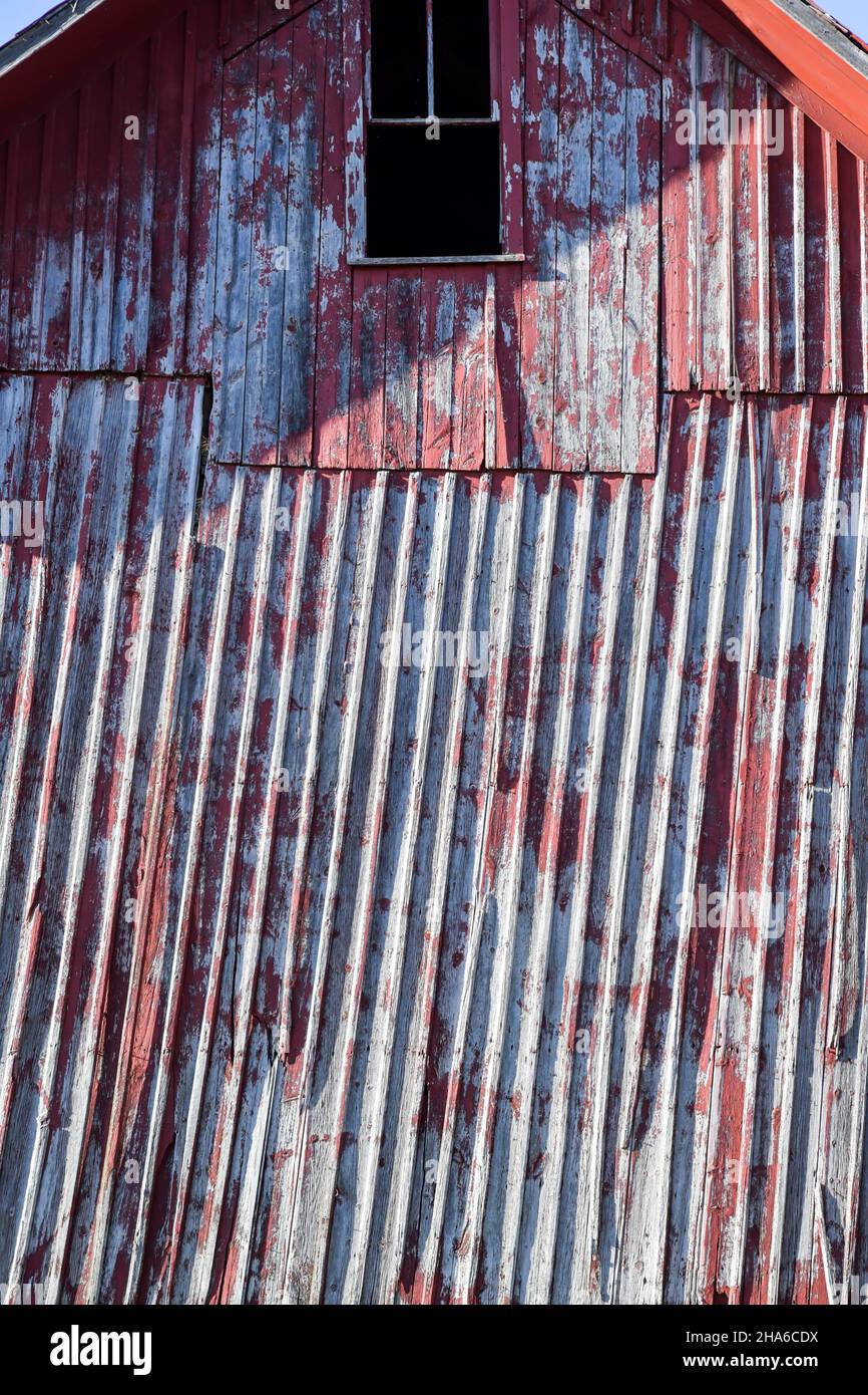 muro di fienile rosso usurato e stagionato sulla fattoria Foto Stock
