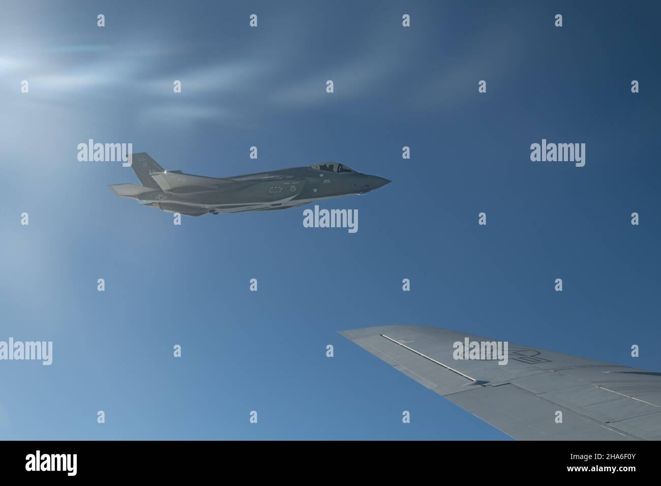 Un US Air Force F-35A Lightning II dal 356th Expeditionary Fighter Squadron, 354th Air Expeditionary Wing, vola accanto al 909th Air Refeling Squadron KC-135 Stratotanker durante l'operazione Iron Dagger sopra l'Oceano Pacifico, 8 dicembre 2021. Durante il Iron Dagger, l'aviazione militare statunitense si è integrata con il F-35B Lightning IIS del Marine Aircraft Group 12 per rafforzare le partnership e migliorare le capacità congiunte, garantendo un libero e aperto Indo-Pacific. (STATI UNITI Air Force foto di Airman 1st Classe Cesar J. Navarro) Foto Stock