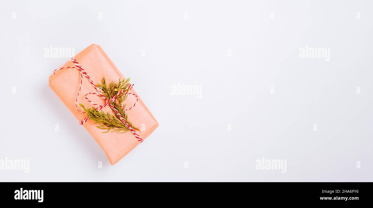 Bella confezione regalo avvolta in carta artigianale su sfondo di carta blu Foto Stock