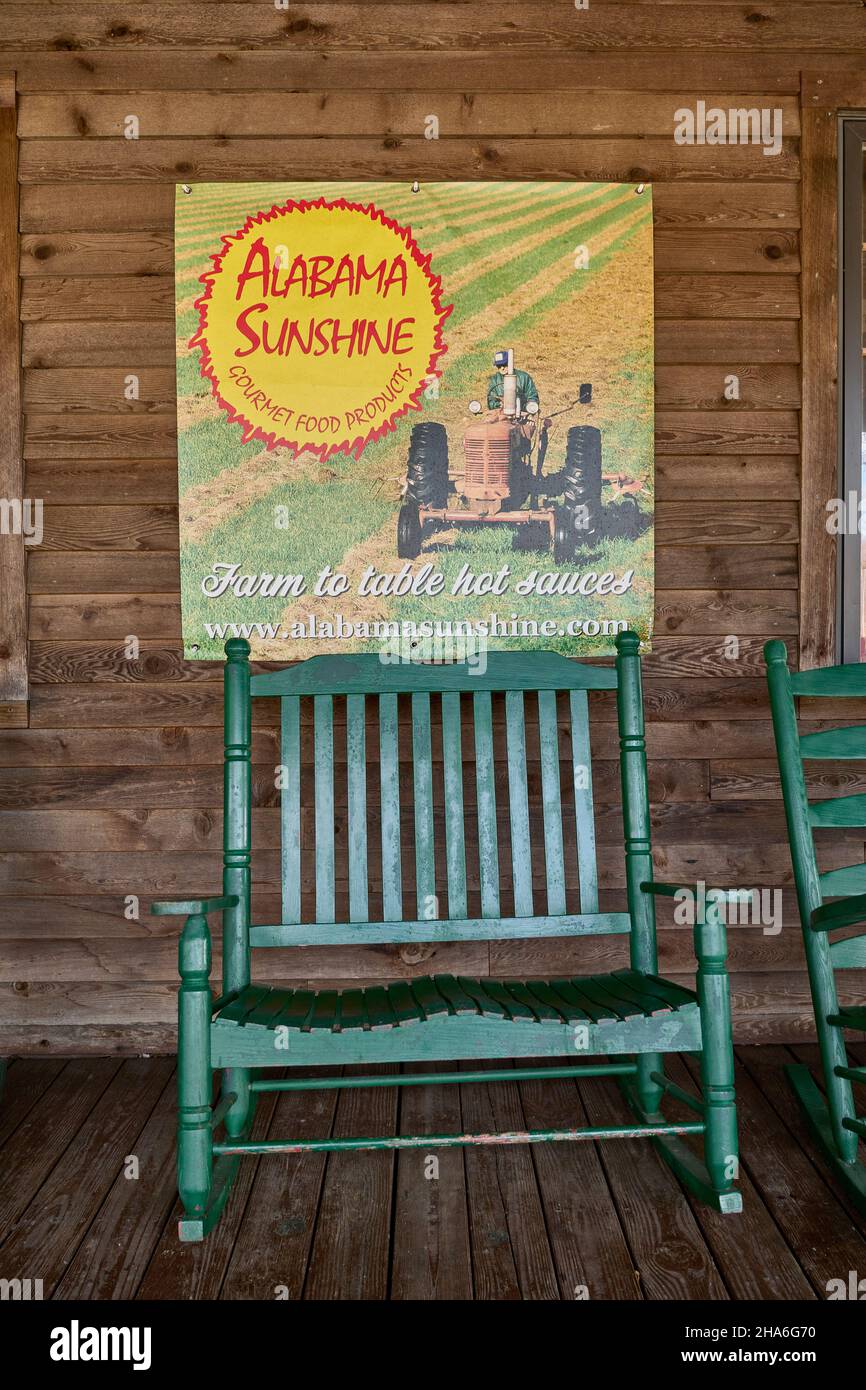 Alabama Sunshine Gourmet Food Products segno sopra una grande sedia a dondolo sul portico di legno di un negozio di campagna in Alabama rurale, Stati Uniti. Foto Stock