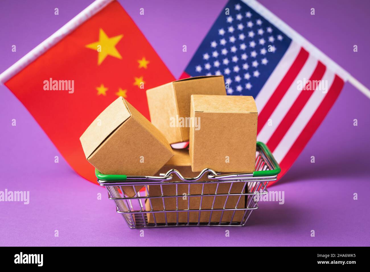 Varie scatole in un cestino di cibo e bandiere di Cina e America su uno sfondo colorato, il concetto di commercio tra i paesi Foto Stock