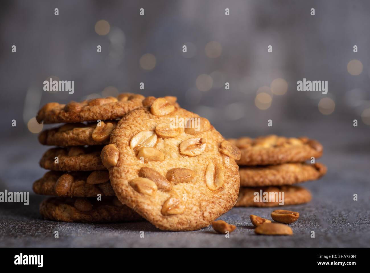 Accatastate i biscotti fatti in casa con le arachidi su un mucchio su sfondo grigio Foto Stock