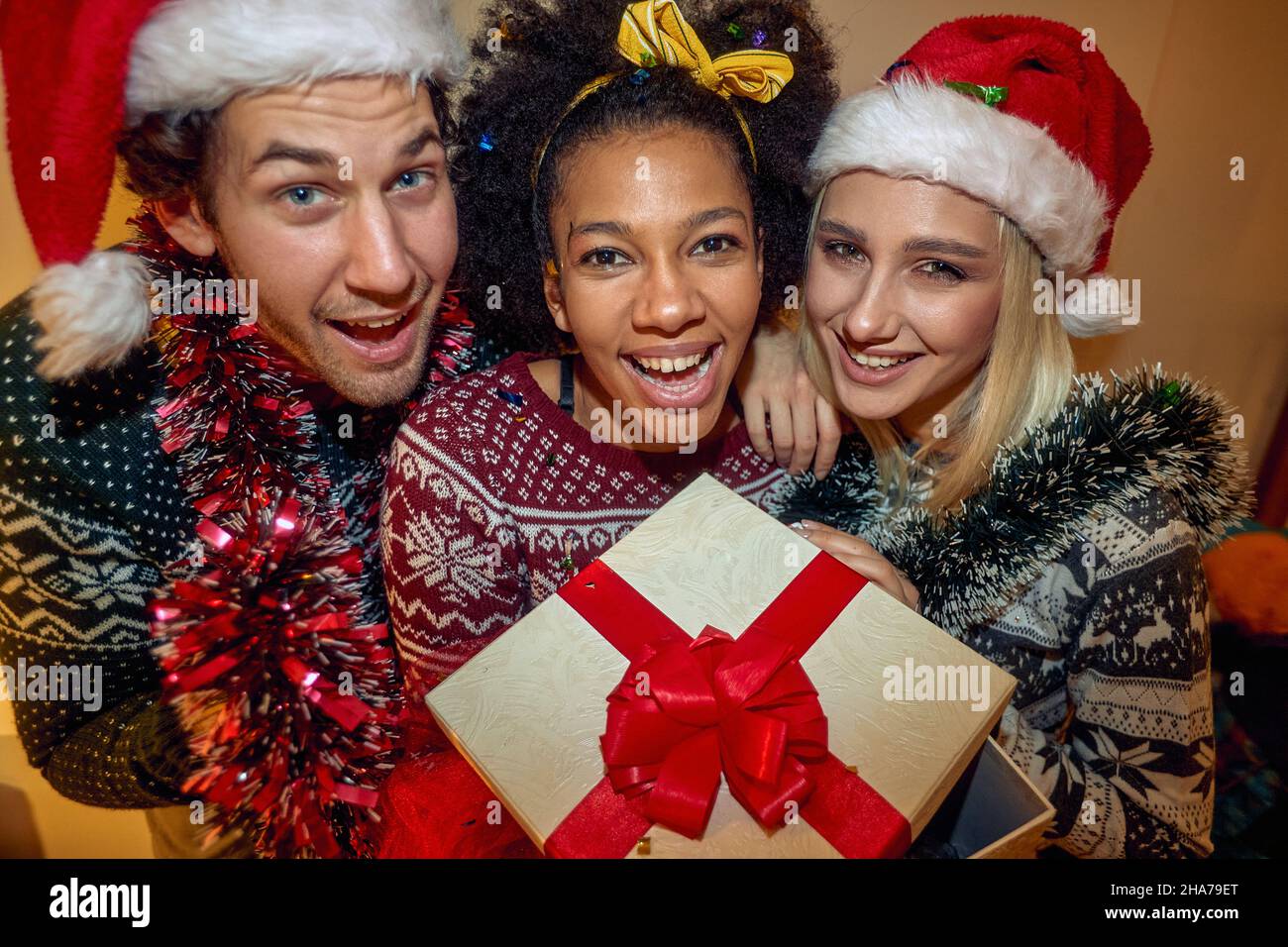 Amici felici a Santa Hat festeggiamenti festa di Natale a casa Foto Stock
