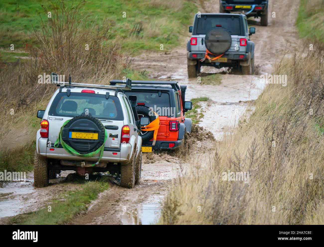 Veicoli fuoristrada 4x4 che attraversano terreni con fango e acqua, Salisbury Plain Wilts Regno Unito. Jeep Rubicon e Cherokee Foto Stock