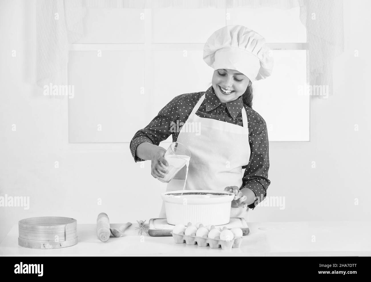 Cibo molto buono. Ingredienti sani. Ragazza felice adolescente pronta per la cottura. Bambino indossare uniforme chef Foto Stock