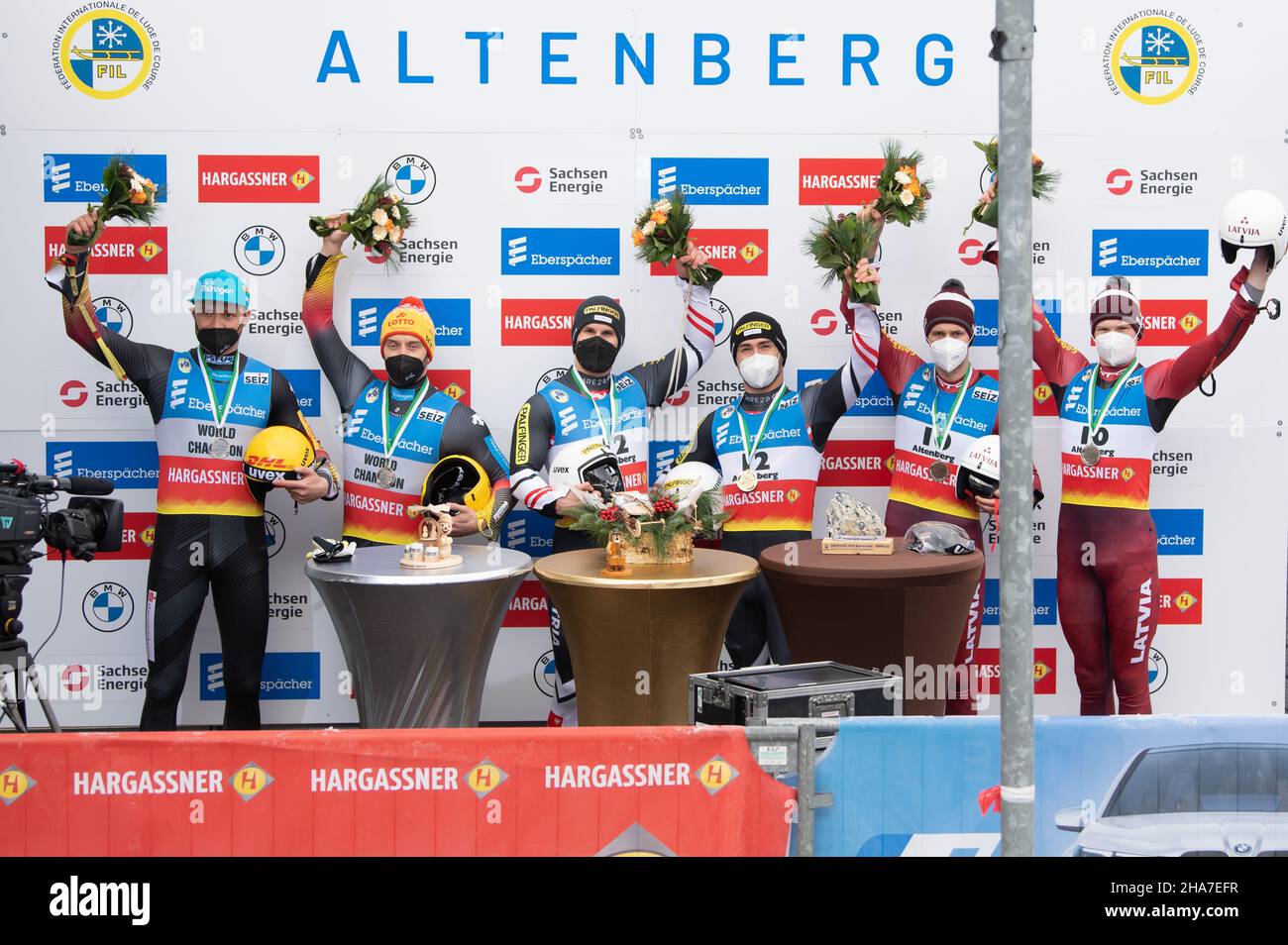 Altenberg, Germania. 11th Dic 2021. Luge: Coppa del mondo doppio, uomini singoli, secondo turno. Toni Eggert (l-r) e Sascha Benecken dalla Germania, Thomas Steu e Lorenz Koller dall'Austria, e Martins Bots e Roberts Plume dalla Lettonia celebrano durante la cerimonia di premiazione. Credit: Kahnert/dpa-Zentralbild/dpa/Alamy Live News Foto Stock