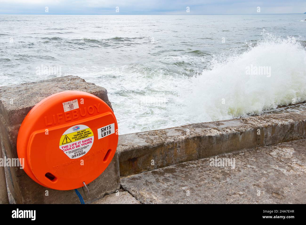 Anello di salvataggio di boa di vita di fronte a onde e mare accidentato in Scarborough Yorkshire Foto Stock