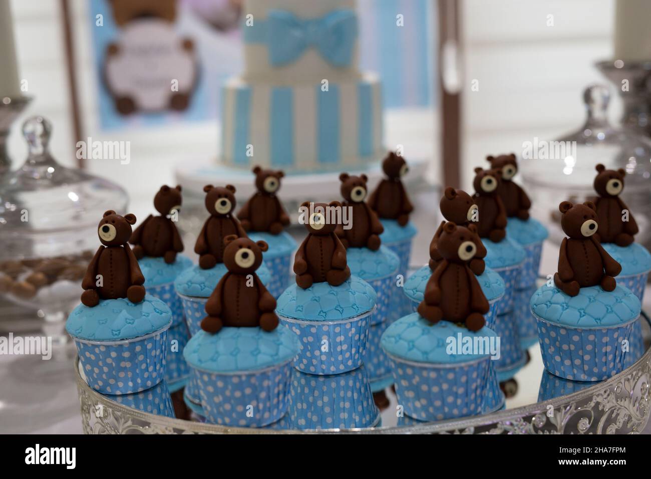Gli orsacchiotti si siedono sulle torte blu che vengono cotte per una festa di compleanno Foto Stock