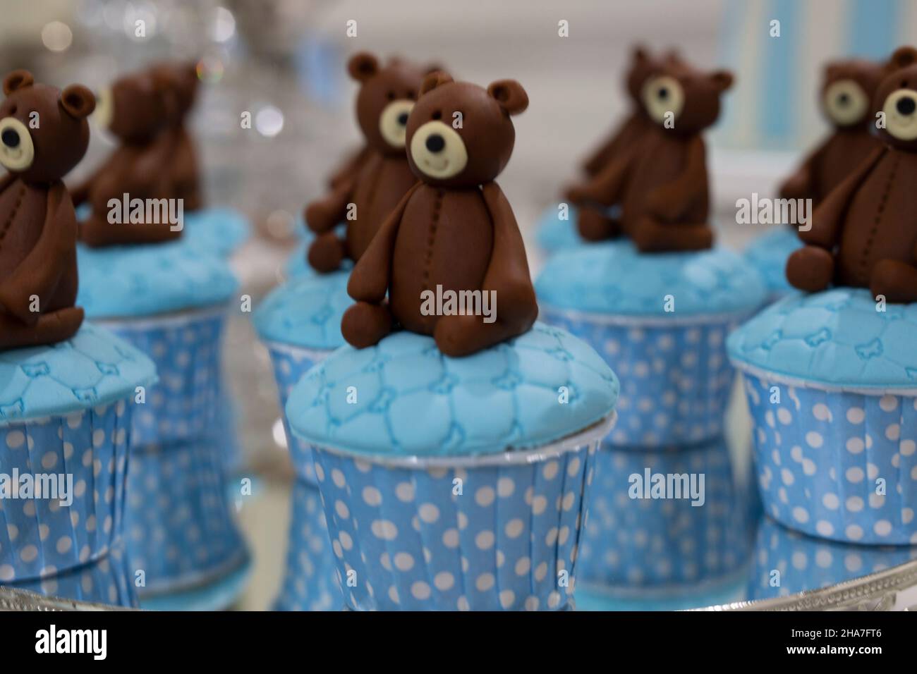 Gli orsacchiotti si siedono sulle torte blu che vengono cotte per una festa di compleanno Foto Stock