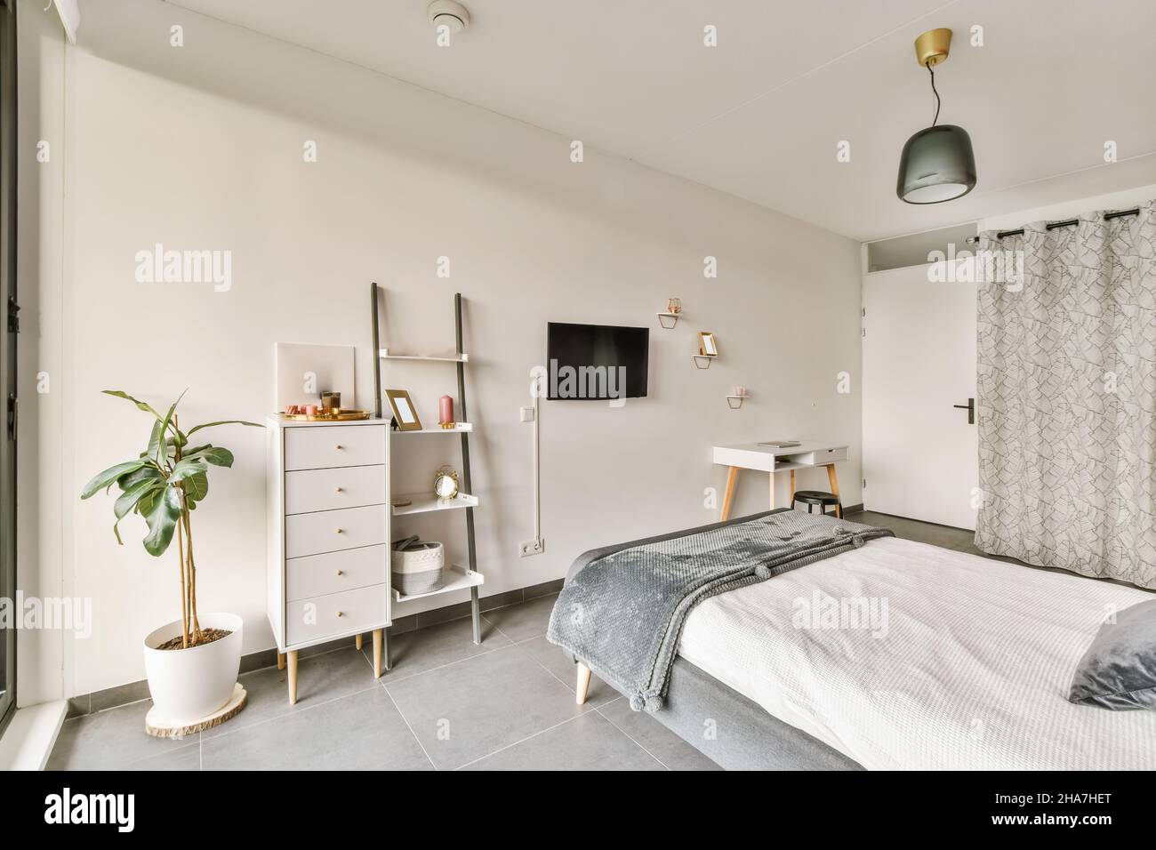 La camera da letto era stupenda, con TV di fronte al letto e lampadario insolito Foto Stock