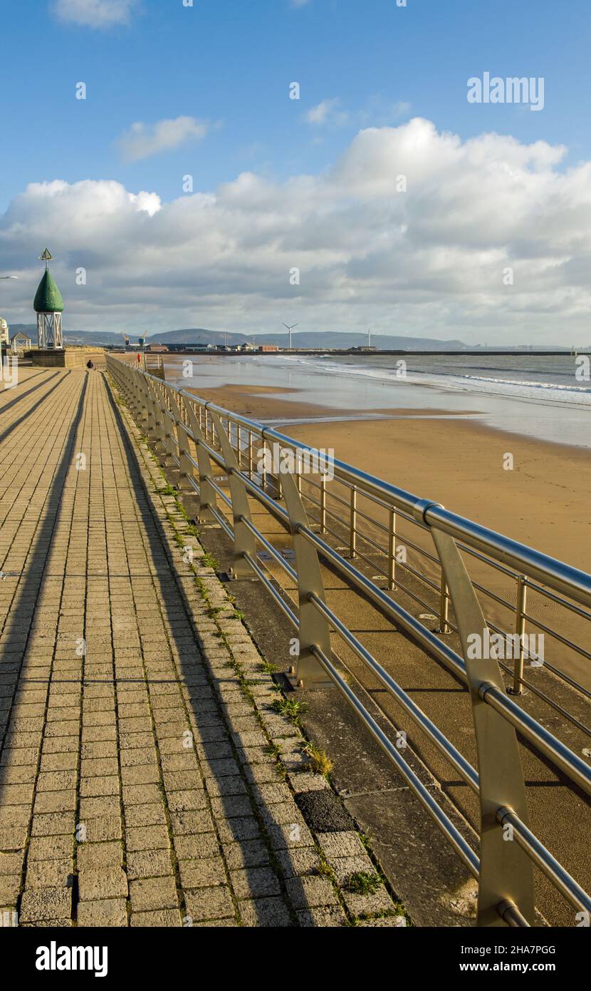 Guardando verso est attraverso e lungo Swansea Bay/Beach in una giornata invernale soleggiata e fredda di dicembre sulla costa meridionale del Galles. Foto Stock
