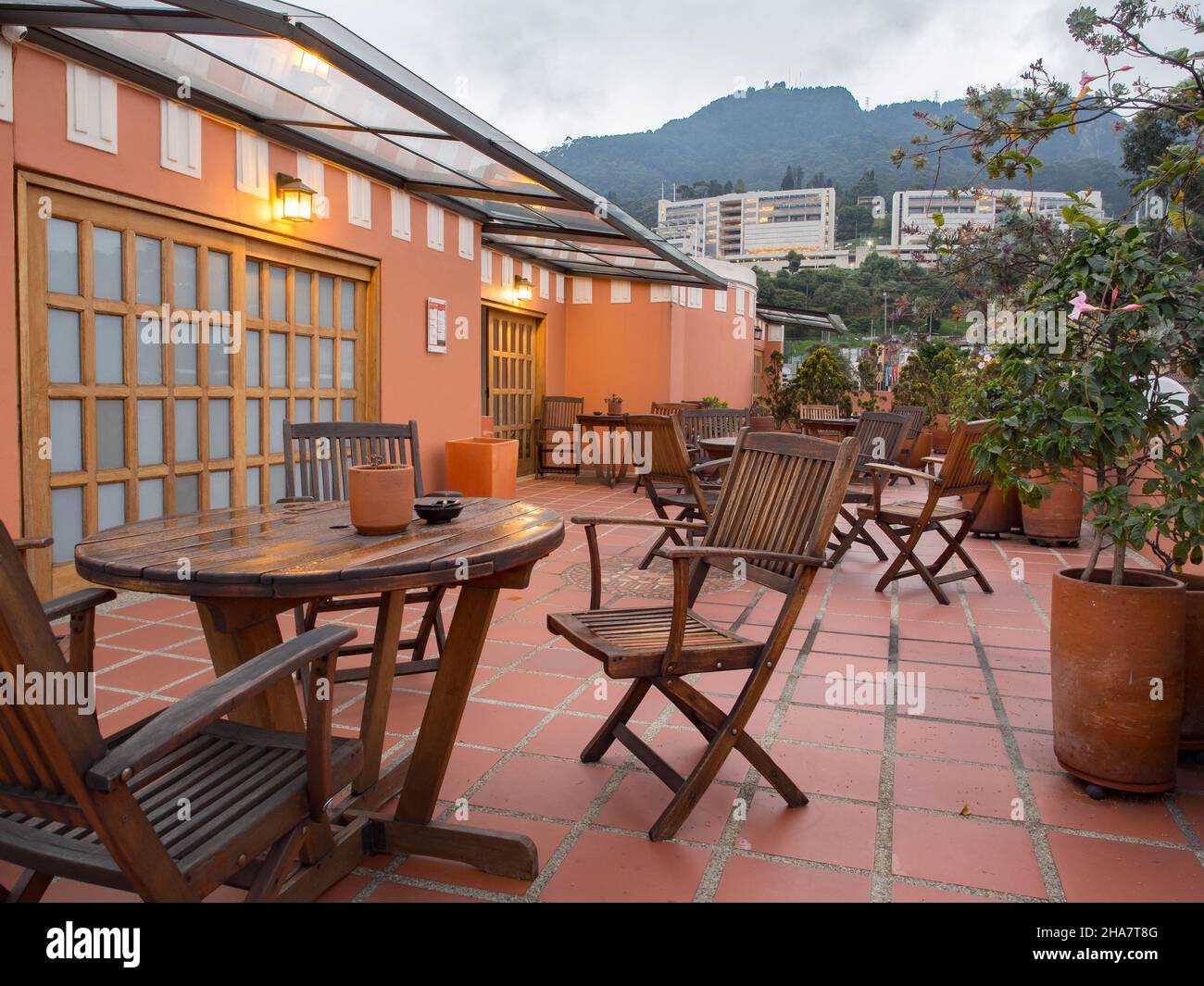 Bogota, Colombia - Settembre 2017: Terrazza in hotel con tavoli e sedie in  legno e vista sulle colline di Monserrate. Sud America Foto stock - Alamy