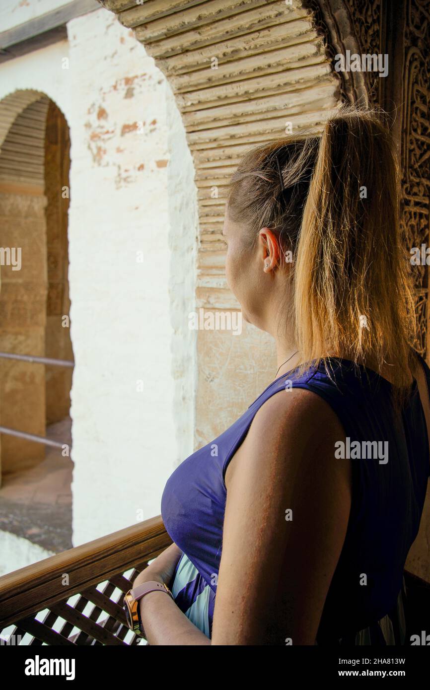 giovane donna che guarda il paesaggio con abito blu Foto Stock
