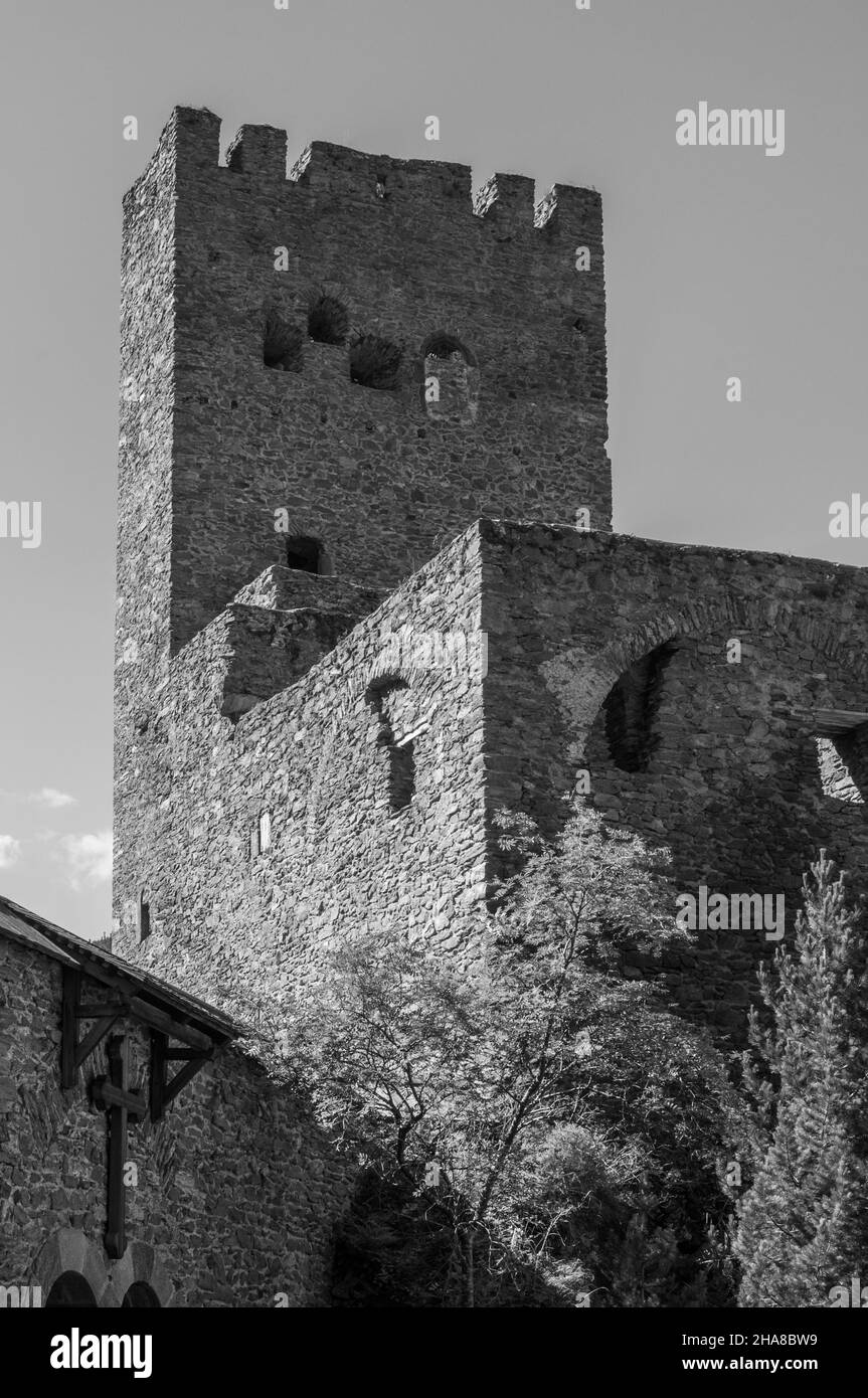 Particolare di un vecchio castello con una torre contro un cielo azzurro chiaro Foto Stock