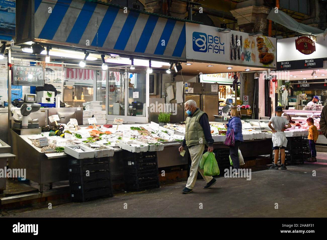 Persone che acquistano pesce fresco al banco del mercato Orientale coperto (MOG) nel centro di Genova, Liguria, Italia Foto Stock