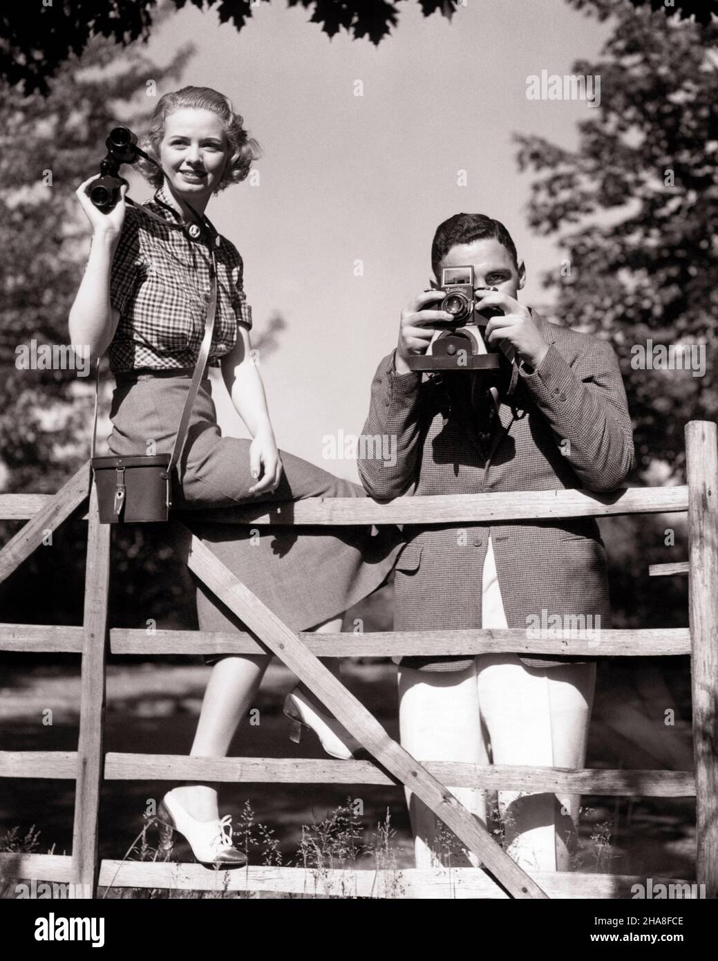 1930S COPPIA GUARDANDO CROSS-COUNTRY EVENTO SPORTIVO UOMO SCATTANDO FOTO CON FOTOCAMERA DONNA TENENDO COPPIA BINOCOLO SEDUTO SUL RECINTO - U343 HAR001 HARS RICCO RELAX RICCO STILE DI VITA FEMMINE SPOSATO EVENTO RURALE CONIUGE MARITI COPIA SPAZIO AMICIZIA MEZZA LUNGHEZZA SIGNORE PERSONE MASCHI SPETTATORI B&W PARTNER EYE CONTATTO INCONTRI ABILITÀ ATTIVITÀ DIVERTIMENTO SPORT AVVENTURA HOBBY OSSERVATORE INTERESSE ED ECCITAZIONE HOBBY CONOSCENZA PASSATEMPO PIACERE ATTRAZIONE UPSCALE WATCHER CORTSHIP AFFLUENT OSSERVARE ELEGANTE VIEWER POSSIBILITÀ CROSS-COUNTRY MID-ADULT MID-ADULT UOMO RELAX ATTIVITÀ SOCIALE INSIEME Foto Stock