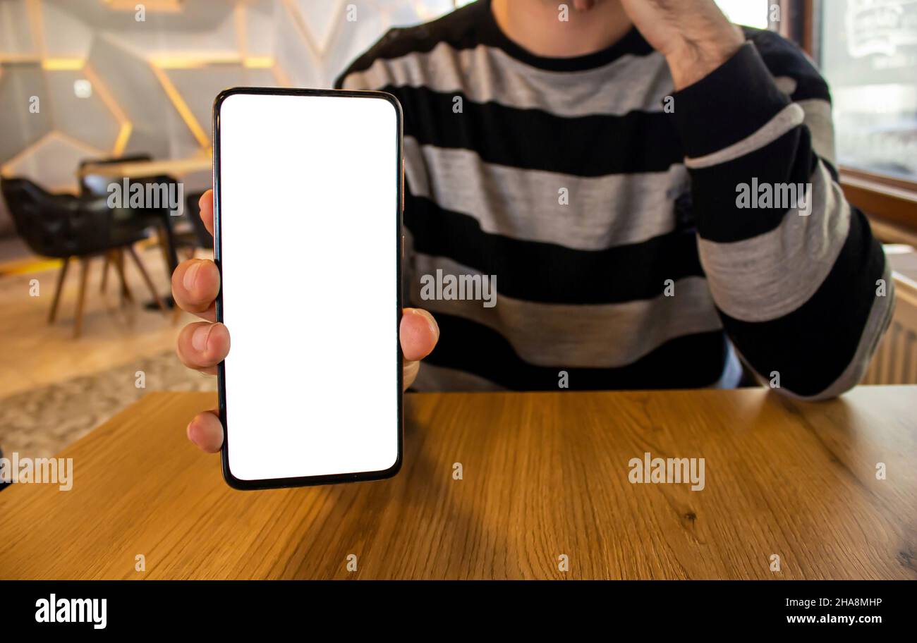 Smartphone uomo con mano, immagine mockup della mano che mostra il telefono cellulare con schermo bianco vuoto. Foto Stock