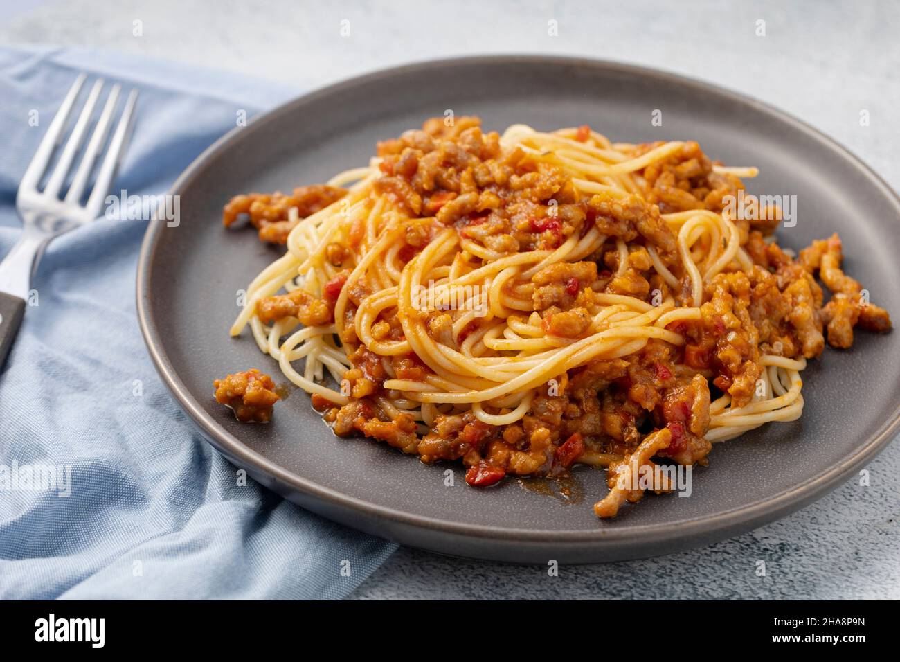 Pasta spaghetti bolognese con salsa di manzo tritata, su fondo concreto. Messa a fuoco selettiva. Foto Stock