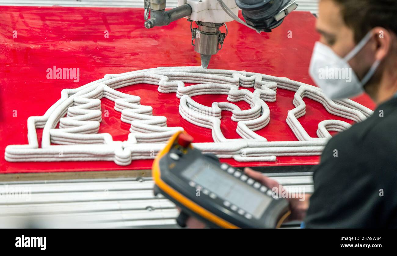 10 dicembre 2021, Sassonia, Chemnitz: Enrico Rudolph dell'area di ricerca "strutture leggere in ingegneria civile" dell'Università di tecnologia Chemnitz segue la produzione di un arco in calcestruzzo flyweight utilizzando un processo di stampa automatizzato 3D. Gli scienziati dell'area di ricerca "Lightweight Construction in Civil Engineering" presso l'Institute of Structural Lightweight Design presso la Chemnitz University of Technology sono alla ricerca di tecnologie automatizzate per la produzione di additivi da cinque anni. Recentemente, hanno presentato il primo 3D-stampato calcestruzzo Schwibbogen del mondo. I Schwibbögen sono 12 Foto Stock