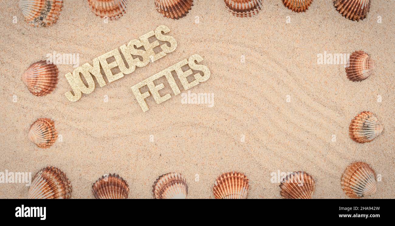 Sfondo sabbia di mare, sabbia fine spiaggia con ciottoli e baubles di Natale. Messaggio buone feste. Foto Stock