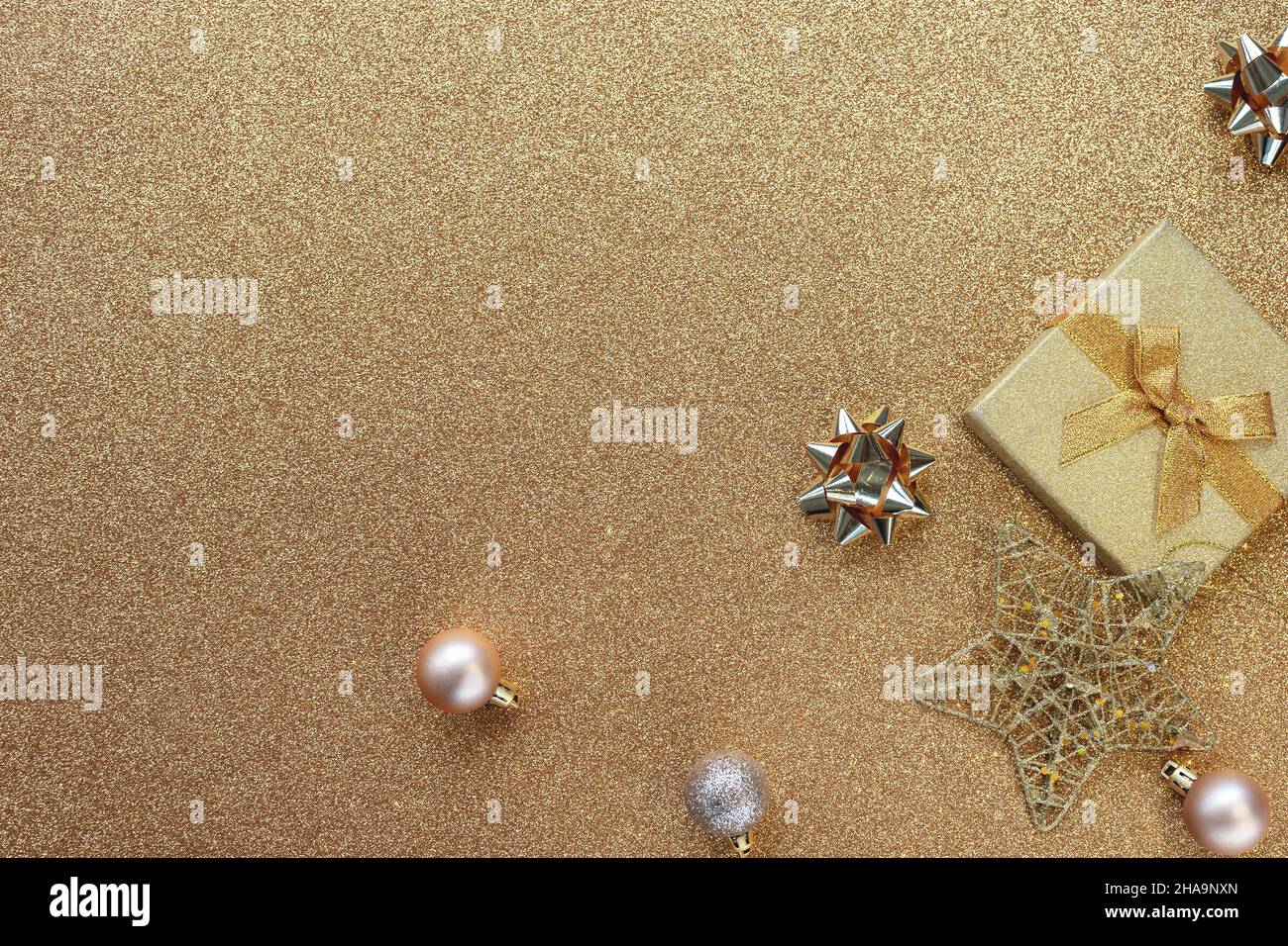 Sfondo inverno di Natale. Scatola regalo, palline e stella sullo sfondo dorato. Concetto di nuovo anno. Vista dall'alto, disposizione piatta, spazio di copia. Foto Stock