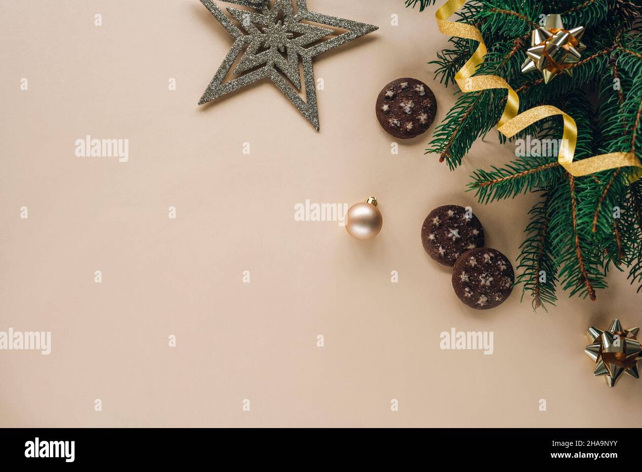 Composizione natalizia su sfondo chiaro con rami di abete, giocattoli, biscotti stellari e al cioccolato. Vista dall'alto, disposizione piatta, spazio di copia. Foto Stock