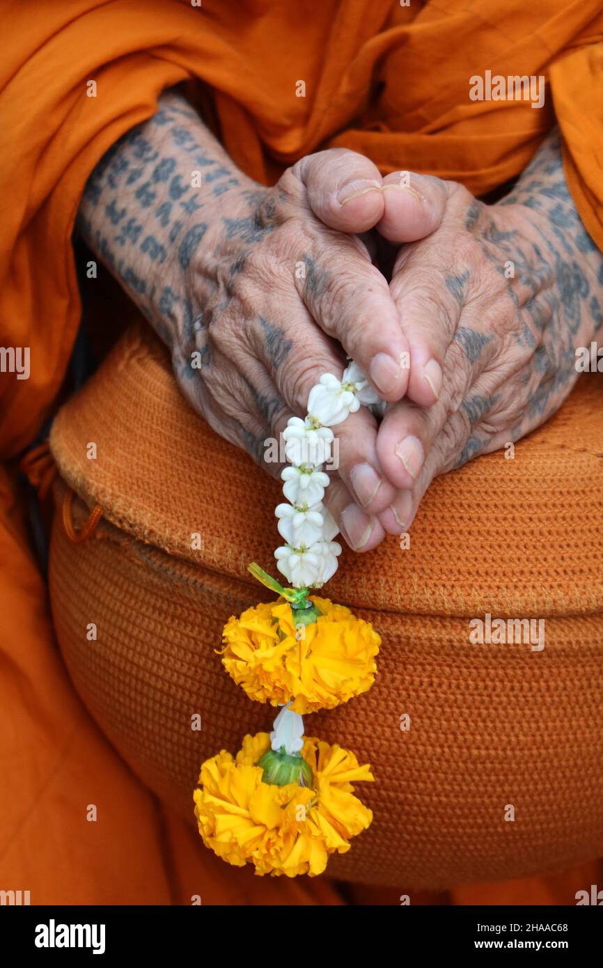 Primo piano di mani monaco buddiste unite con la ciotola di elemosina, Bangkok, Thailandia Foto Stock