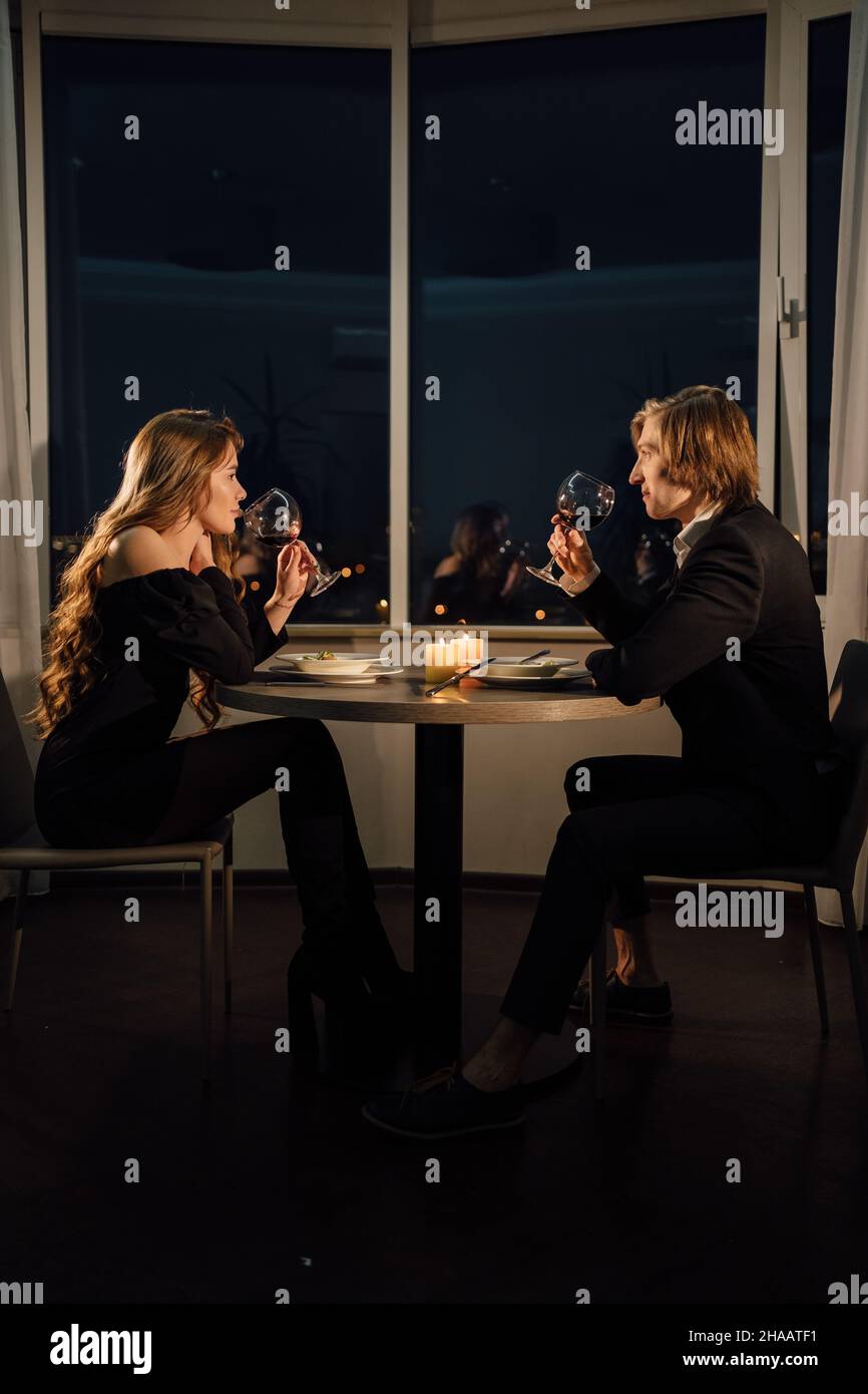 Cena romantica per due coppie bevendo vino rosso, appuntamento a casa di notte al tavolo, San Valentino festa, uomo e donna relazione Foto Stock