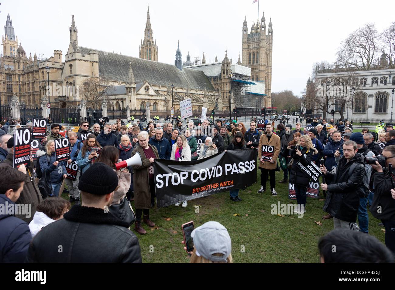 I manifestanti hanno visto radunare in Piazza del Parlamento, tenendo in mano una bandiera che dice "passa il copovid di arresto" durante la dimostrazione. Condotto congiuntamente da Big Brother Watch e Migrant Organize, I manifestanti si sono riuniti per esprimere il malcontento in relazione al tentativo del governo britannico di rendere i passaporti dei vaccini e altre forme di COVID ID un requisito per gli eventi su larga scala e l'ingresso negli spazi pubblici. Il gruppo cerca di delineare chiaramente la differenza tra i passaporti specifici anti-vaccino e i vaccini, con i quali si identificano con i primi. Foto Stock