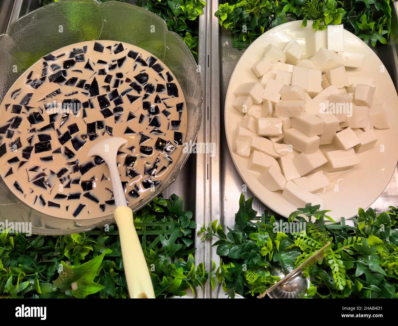 Dessert thailandesi tradizionali con torte di cocco bianche e gelatina nera, cucina thailandese. Foto Stock