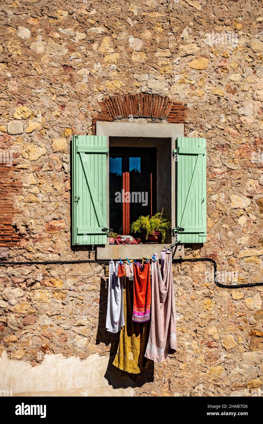Vestiti che asciugano al sole su un balcone casa a Cessenon sur Orb, Francia Foto Stock