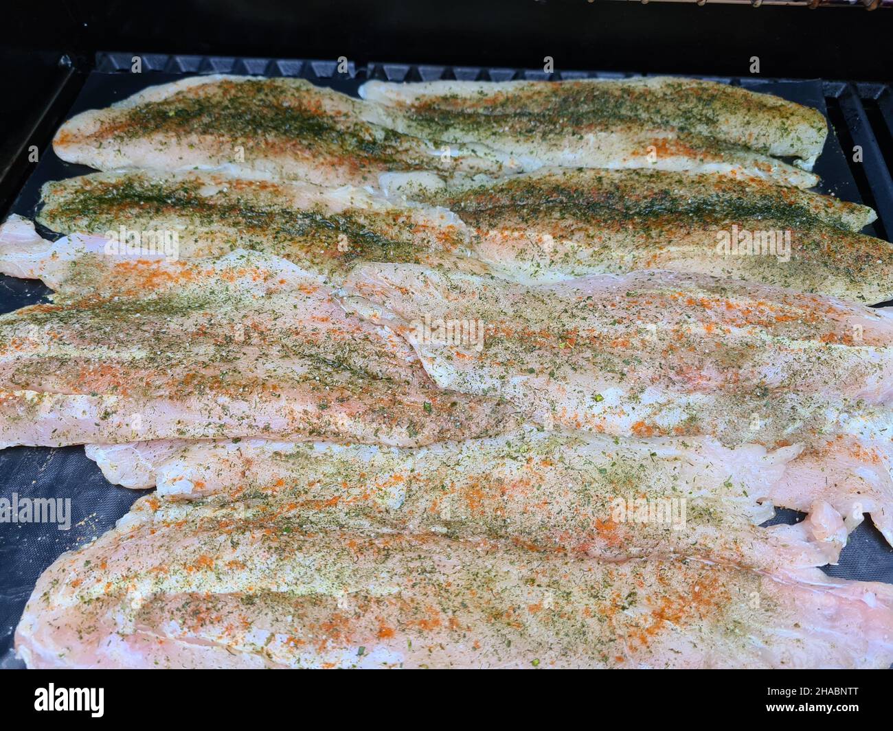 Chef professionista che cucinano pesce su un barbecue Foto Stock