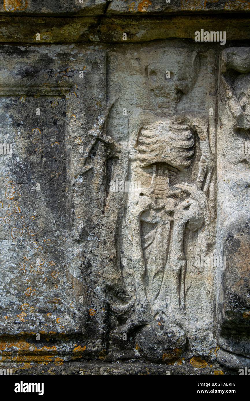 Una scultura in pietra di uno scheletro sul lato di una tomba Foto Stock