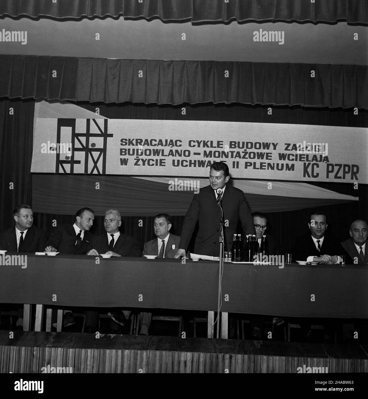 Warszawa, 1969-11-03. Uroczyste otwarcie pi¹tej z kolei walcowni œrednio - drobnicowej w Hucie Warszawa. NZ. w prezydium m.in.: sekretarz Komitetu Centralnego (KC) Alojzy Karkoszka (3L), cz³onek Biura Politycznego, sekretarz KC Boles³aw Jaszczuk (4L), ministro budownictha Andrzej Giersz (6L). W tle has³o: Skracaj¹c cykle budowy za³ogi budowlano - monta¿owe wcielaj¹ w ¿ycie uchwa³ê II plenum KC PZPR. Ad PAP/Muszyñski Varsavia, 3 novembre 1969. Apertura di gala del mulino di metallo 5th a Warsaw Steelworks. Raffigurato al tavolo del Presidium: segretario del Comitato Centrale del lavoro congiunto polacco Foto Stock