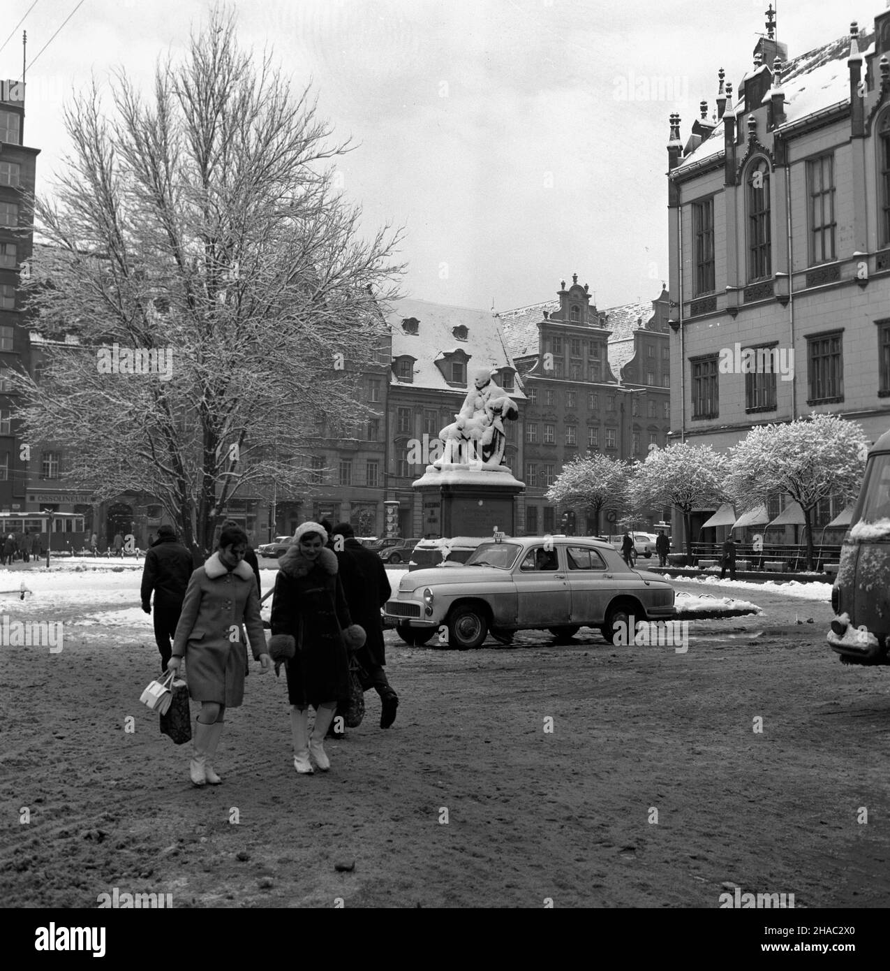 Wroc³aw, 1969-11-26. Widok na Rynek, œredniowieczny plac targowy, jeden z najwiêkszych placów w Europie. Powsta³ w zwi¹zku z lokacj¹ Wroc³awia za czasów Henryka Brodatego miêdzy 1214 a 1232 r. Rynek otaczaj¹ budynki pochodz¹ce z RÓ¿nych epok historycznych. Na pierwszym planie pomnik Aleksandra Fredry. uu PAP/Eugeniusz Wo³oszczuk Wroclaw, 26 novembre 1969. Vista sul mercato medievale, uno dei più grandi d'Europa, costruito dopo che la città fu fondata ai tempi di Henryk Brodaty tra il 1214 e il 1232. Il luogo è circondato da edifici che provengono da diverse epoche storiche. Pictur Foto Stock