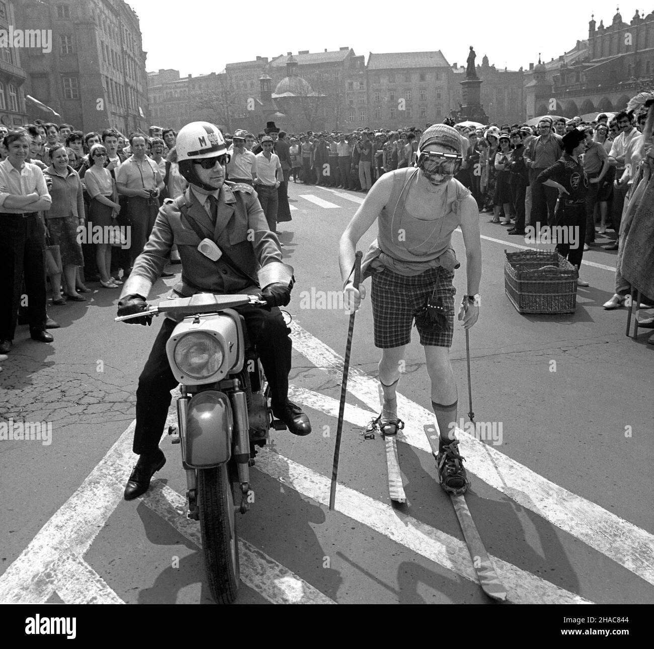 Kraków 05,1971. Zabawy studentów podczas juwenaliów na Rynku G³ównym. meg PAP/Jan Morek Dok³adny dzieñ wydarzenia nieustalony. Cracovia, Polonia, maggio 1971. Uno studente che scia su una strada accanto a un ufficiale di polizia su una moto durante le celebrazioni di Juwenalia nella piazza principale di Cracovia. Juwenalia è una vacanza annuale degli studenti. PAP/JAN MOREK Foto Stock