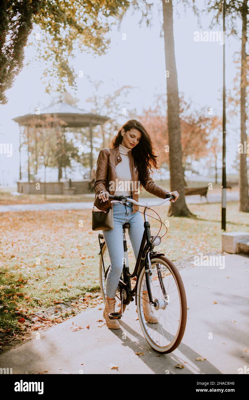 Bella giovane donna in bicicletta il giorno d'autunno Foto Stock