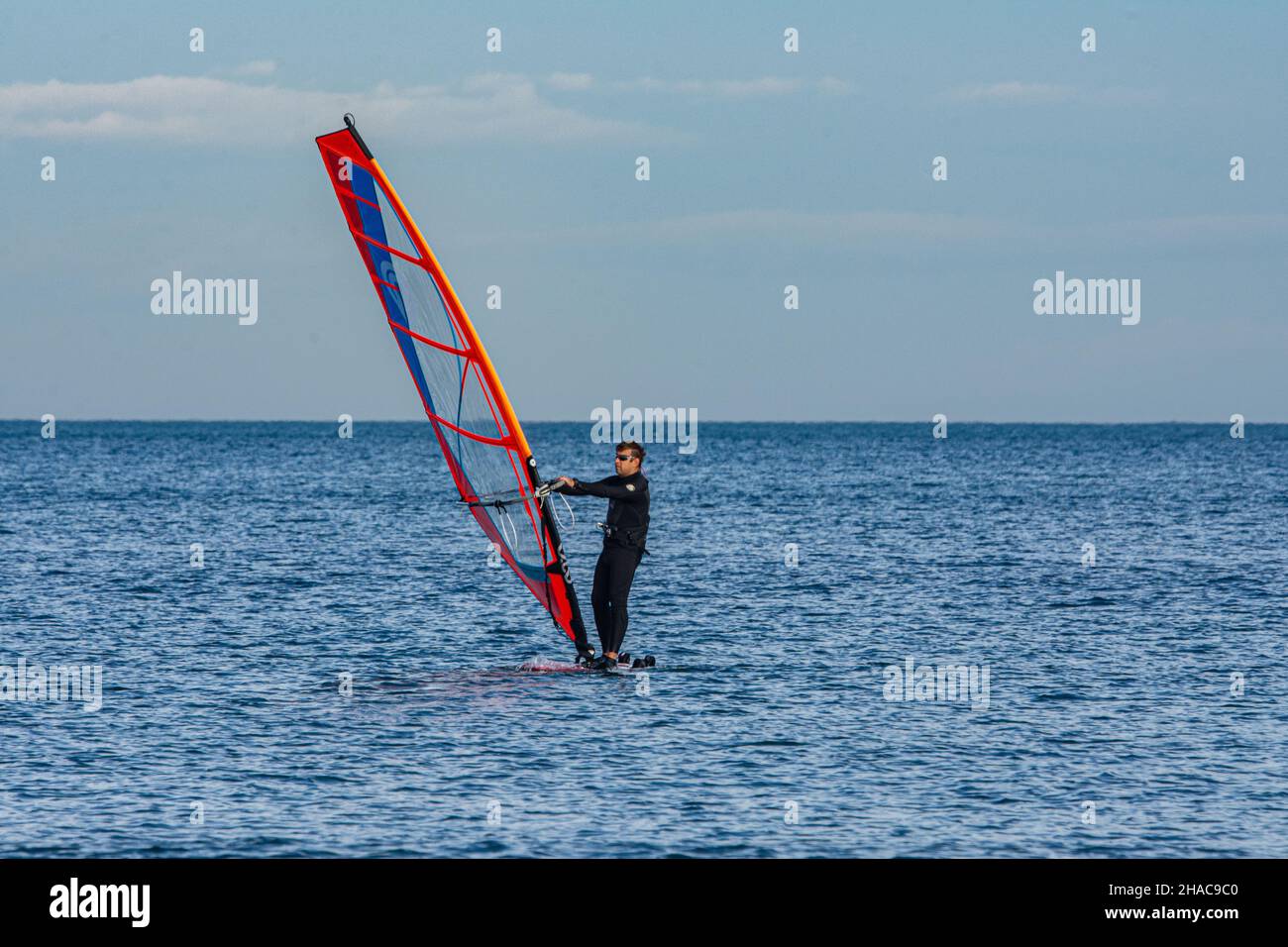 'Port Saplaya, Spagna - 12.10.2021: Windsurf. Surfer esercitarsi in mare calmo o in oceano." Foto Stock