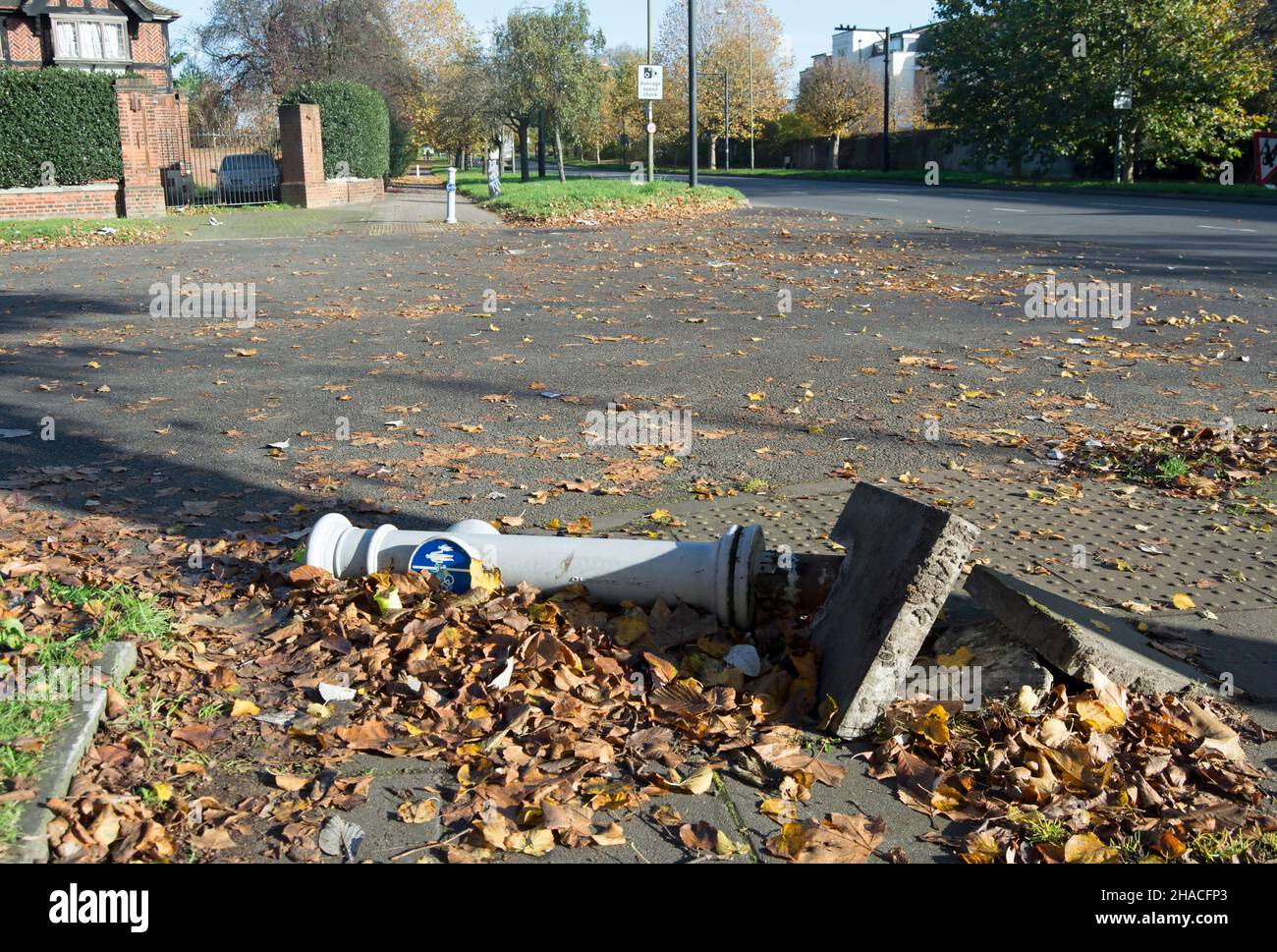 pietre di pavimentazione danneggiate e un bullard bussato, indicando le corsie per ciclisti e pedoni, fuori mortlake cimitero sud-ovest di londra, engand Foto Stock