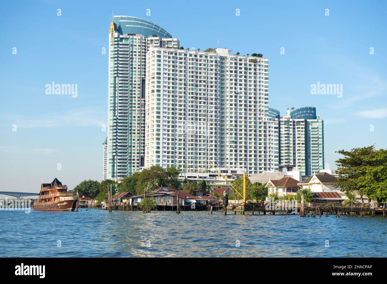 BANGKOK, THAILANDIA - 01 GENNAIO 2019: Moderno complesso residenziale a più piani sulle rive del fiume Chao Phraya in una giornata di sole Foto Stock