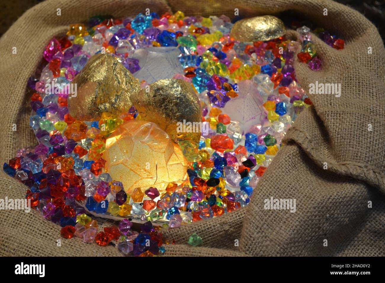 Gemme di cristallo di plastica acriliche miste come gioiello di caccia al tesoro in Jute Sack per il merchandising della finestra del negozio di moda. Il bagliore al buio. Foto Stock