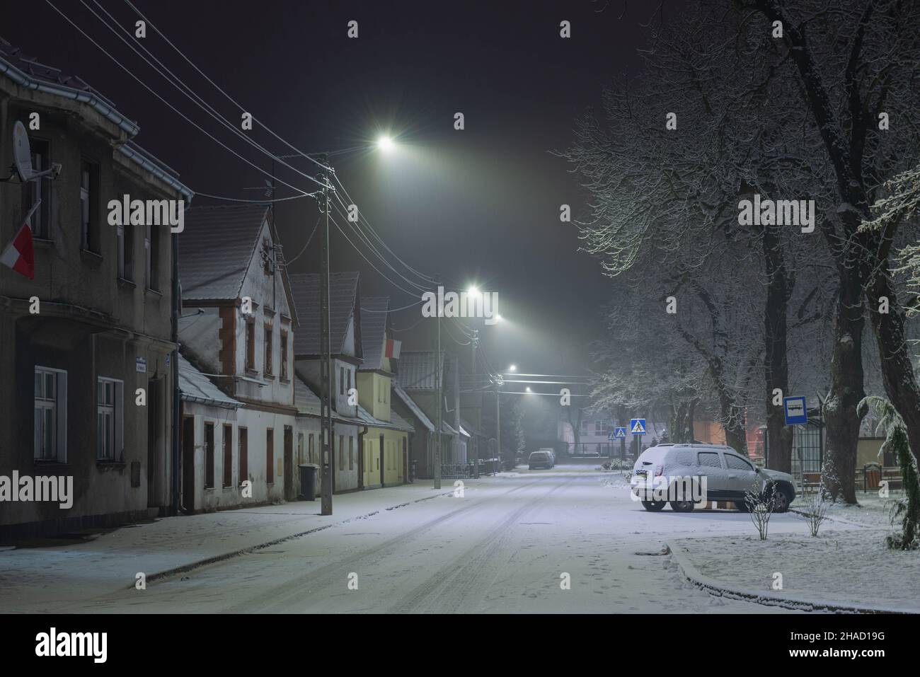 Una città provinciale in Polonia in una serata invernale nevosa. Strada in una piccola città provinciale di Ilowa in Polonia. Foto Stock