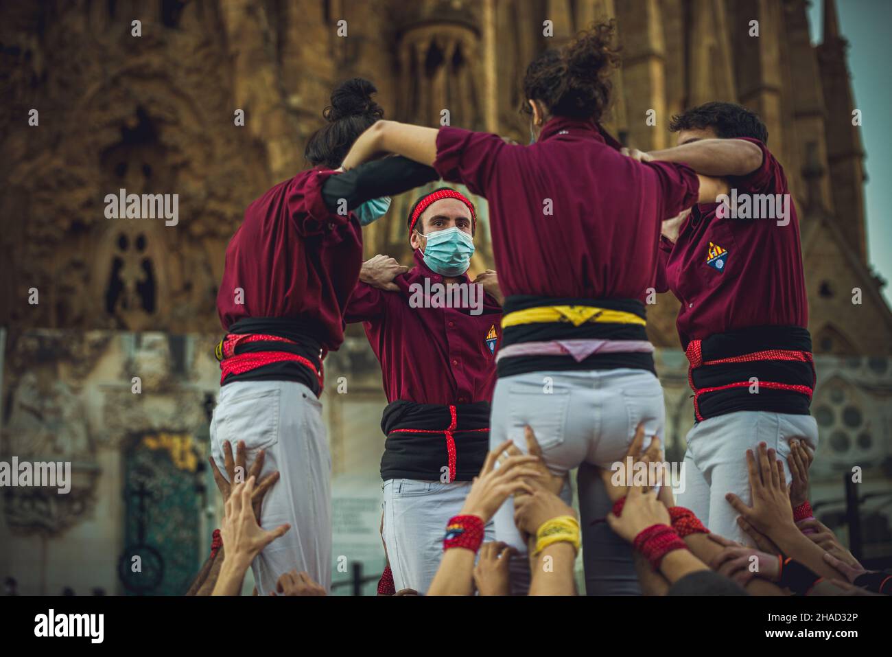 Barcellona, Spagna. 12th Dic 2021. I "Castellers de Sarria" costruiscono una torre umana di fronte alla Sagrada Familia per celebrare il completamento della "Virgin Mary Tower", la sua seconda torre più alta coronata da una stella gigante di cristallo. A causa della crisi Corona-Virus, la data di completamento è stata posticipata e non ci sarà una nuova data annunciata fino al 2024, quando si spera che i lavori di nuovo al ritmo del 2019. Credit: Matthias Oesterle/Alamy Live News Foto Stock