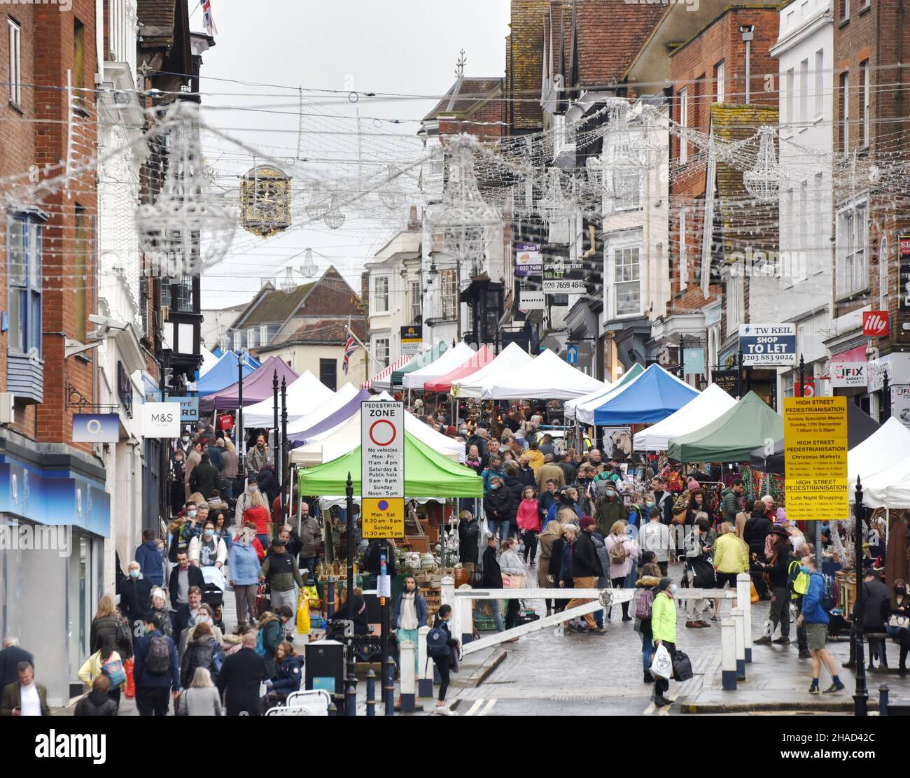 Folle di persone che visitano un mercato a Guildford High Street, apparentemente ignaro dell'attuale situazione di Covid-19, nel dicembre 2021 Foto Stock