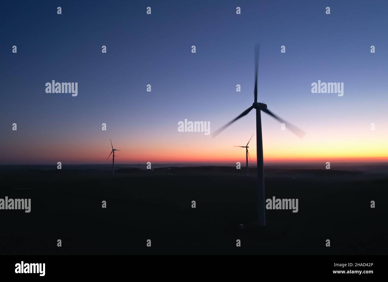 Tre sagome di eliche rotanti di turbine eoliche sullo sfondo del cielo notturno. Foto Stock