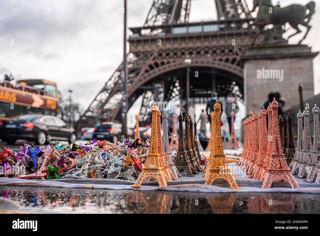 Souvenir della torre Eiffel con una vera torre Eiffel sullo sfondo. Foto Stock