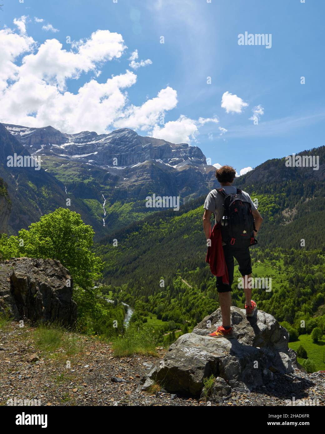 un alpinista che guarda il paesaggio su una roccia Foto Stock